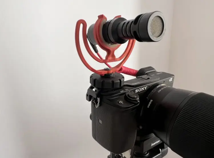 DSLR camera equipped with a RODE microphone mounted on top, showing professional podcasting equipment like what content creators use for video and audio recording.