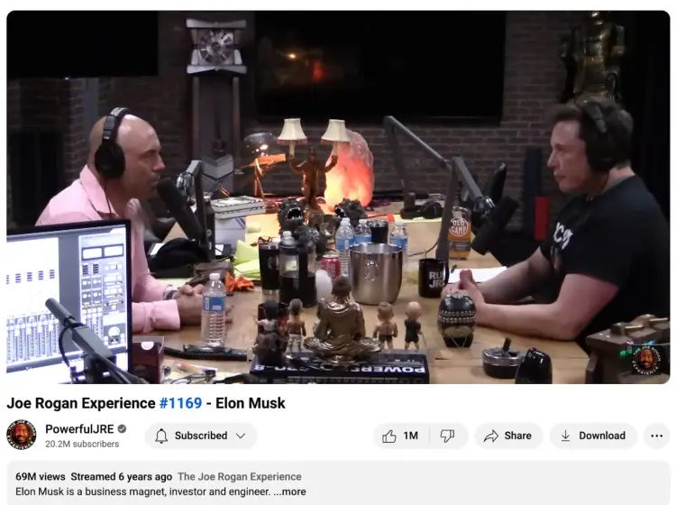 Podcast studio setup showing Joe Rogan interviewing Elon Musk, with microphones, headphones, and decorations visible in the image.