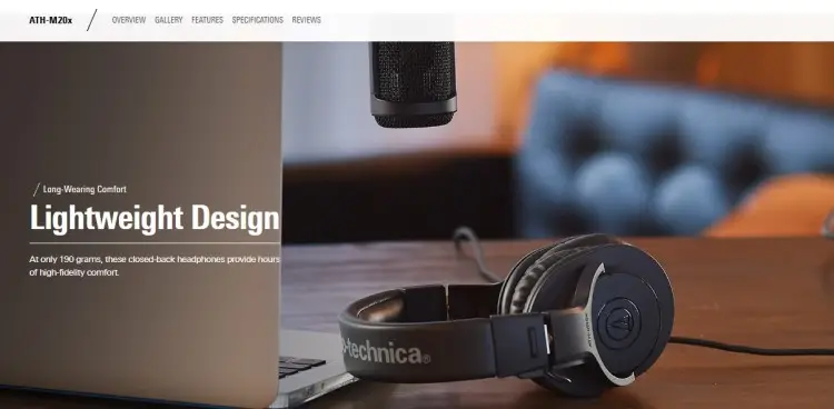 Audio-Technica headphones and a studio microphone on a desk setup designed for podcasters.