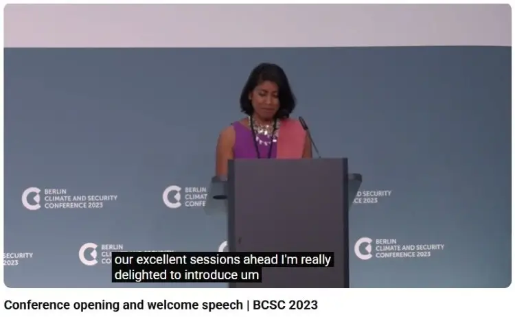 Conference host standing at a podium during an event introduction session