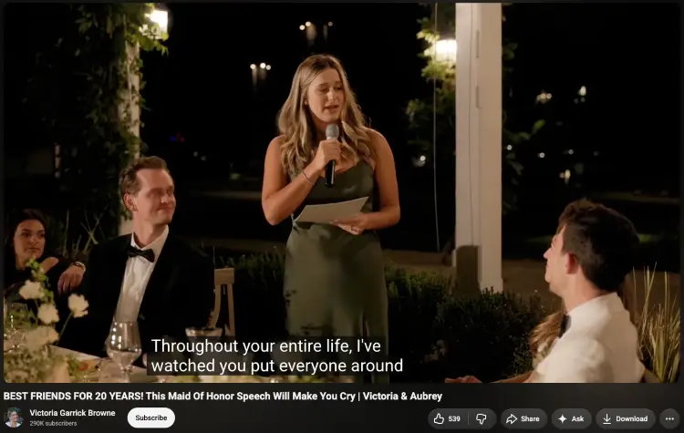 Bridesmaid delivering a maid of honor wedding speech during a wedding reception while the bride and groom listen.