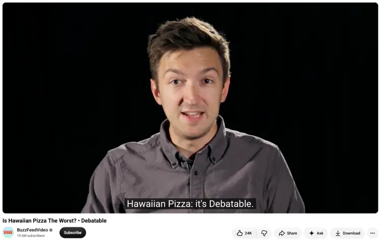 Speaker discussing Hawaiian pizza as an example of funny debate questions