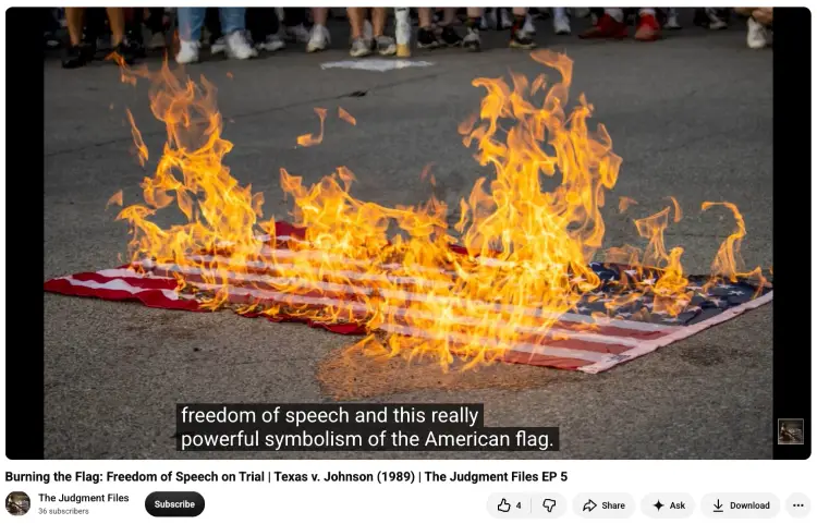 American flag engulfed in flames on a street during a protest, illustrating the act of burning a flag as a form of political expression.