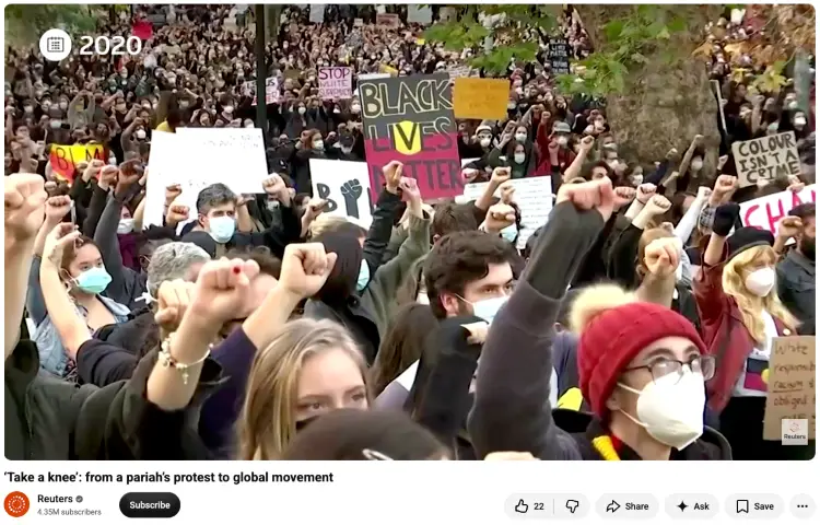 Large crowd of Black Lives Matter protesters raising their fists and holding signs, demonstrating how collective gestures and symbols conveys a message of solidarity and resistance.