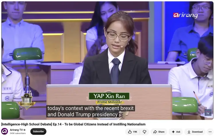 High school student discussing global issues during a televised debate about global citizenship and nationalism.